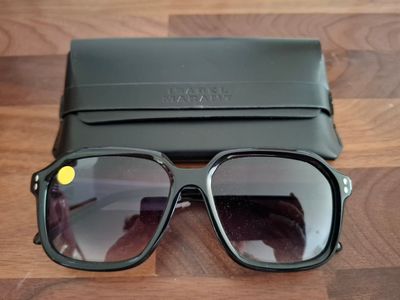 une paire de lunettes de soleil posée sur une table à côté d'un étui