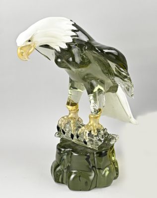 statue of an eagle perched on a rock on a white background