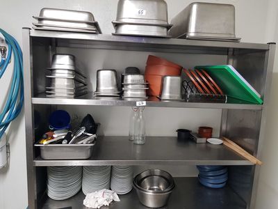 une étagère en métal sur laquelle sont posés des casseroles et des poêles