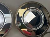 two silver plates on a table with a mirror in the background