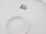 the bottom of a white plate with a green and white design on it