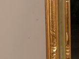a mirror with a gold frame on a white background