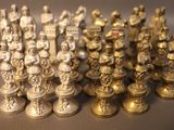 a lot of gold and silver chess pieces on a table
