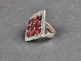 a close up of a silver ring with red stones on it