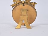 gold plated metal object with a crown on top of it on a white surface