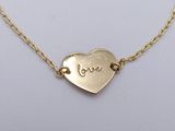 a gold heart necklace with the word love written on it