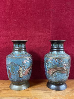 deux vases posés sur une table en bois, avec un mur rouge en arrière-plan