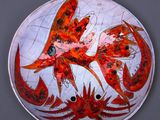 une assiette sur laquelle est représentée une femme et deux crabes