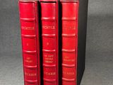trois livres rouges superposés sur une table