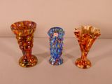 three different colored vases sitting on a table