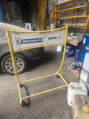 a sign that says michel opel on it in front of a car