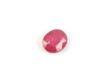 a close up of a pink ruby stone on a white surface
