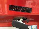 a close up of a red car with a ruler on it ' s side