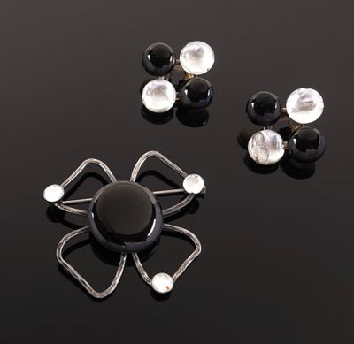 two pairs of black and white earrings on a black surface