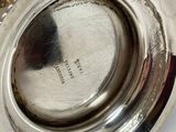 an antique silver plate with a silver lid on a white surface