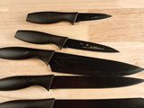 four knives are lined up on a cutting board on a table