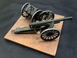 a small model of a cannon on a wooden base
