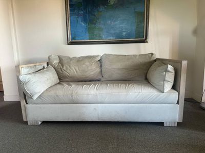 a couch that is sitting in a room with a painting on the wall