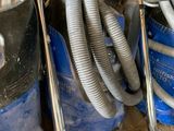 a pile of vacuum cleaners and other items in a room