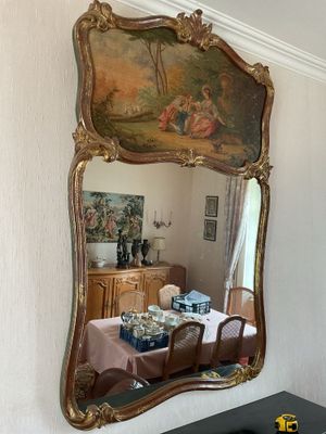 a large mirror hanging on the wall above a dining room table