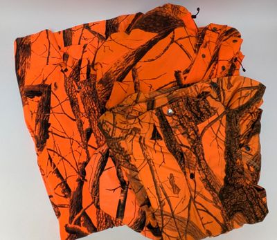 une pile de chemises de camouflage orange posée sur une surface blanche