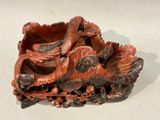 a red vase with a dragon on it sitting on a table