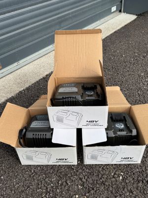 deux cartons contenant deux radios noires et une blanche, posés par terre