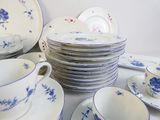 a lot of blue and white plates and cups on the table