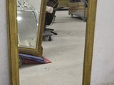 un miroir posé sur le sol à côté d'une chaise