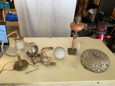 une table sur laquelle se trouvent un ordinateur portable, une lampe et d'autres objets