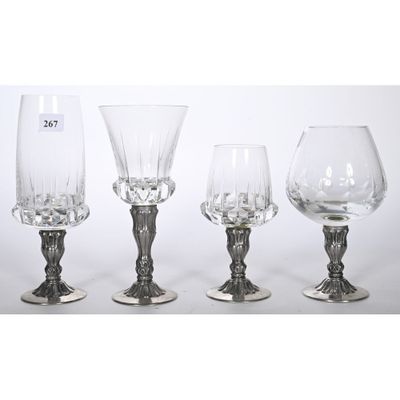 trois verres à pied et un verre à vin posés sur une table