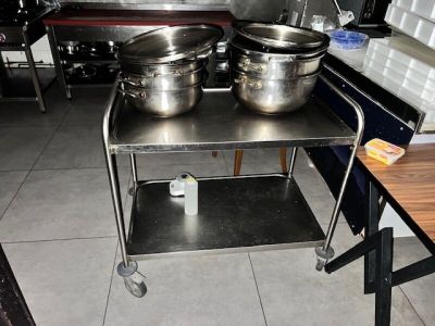 deux grandes casseroles posées sur un chariot en métal dans une cuisine