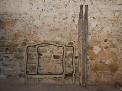 two skis leaning against a brick wall next to a chair