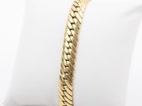 a gold bracelet on a white pillow on a white pillow