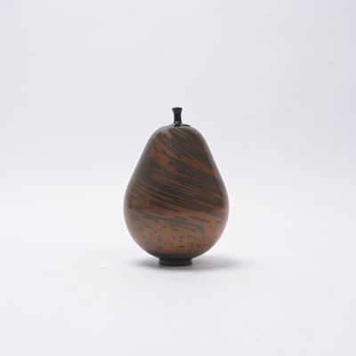 un petit objet en bois posé sur une surface blanche