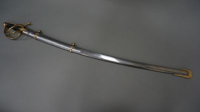 an old sword with a gold handle on a gray surface