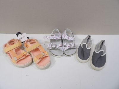 trois paires de chaussures de bébé sont alignées sur une table