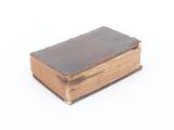 an old book sitting on top of a white surface