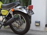 a green motorcycle parked in front of a white building