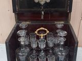 des bouteilles et des verres dans une caisse en bois posée sur une table en marbre