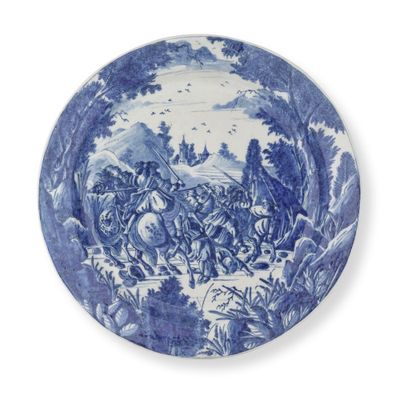 une assiette bleue et blanche sur laquelle est représenté un homme à cheval
