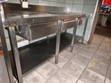 une table en acier inoxydable avec un tiroir en dessous, dans une cuisine