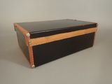 a black and tan trunk sitting on a white surface
