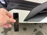 a person holding a ruler in front of a car