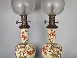 une paire de lampes ornées de motifs d'oiseaux et de fleurs, posées sur une table