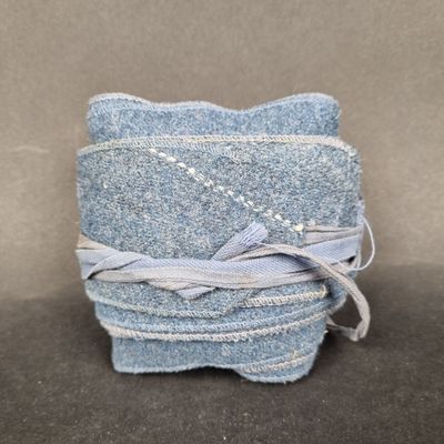 three pieces of blue denim are stacked on top of each other