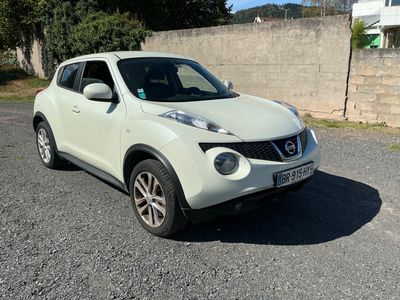a white nissan juke parked in a parking lot