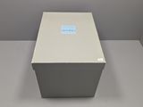 a white box sitting on top of a table next to a gray wall