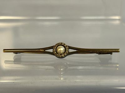 gold plated hair clip with a pearl in the center of it