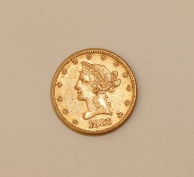 a close up of a gold coin on a white surface